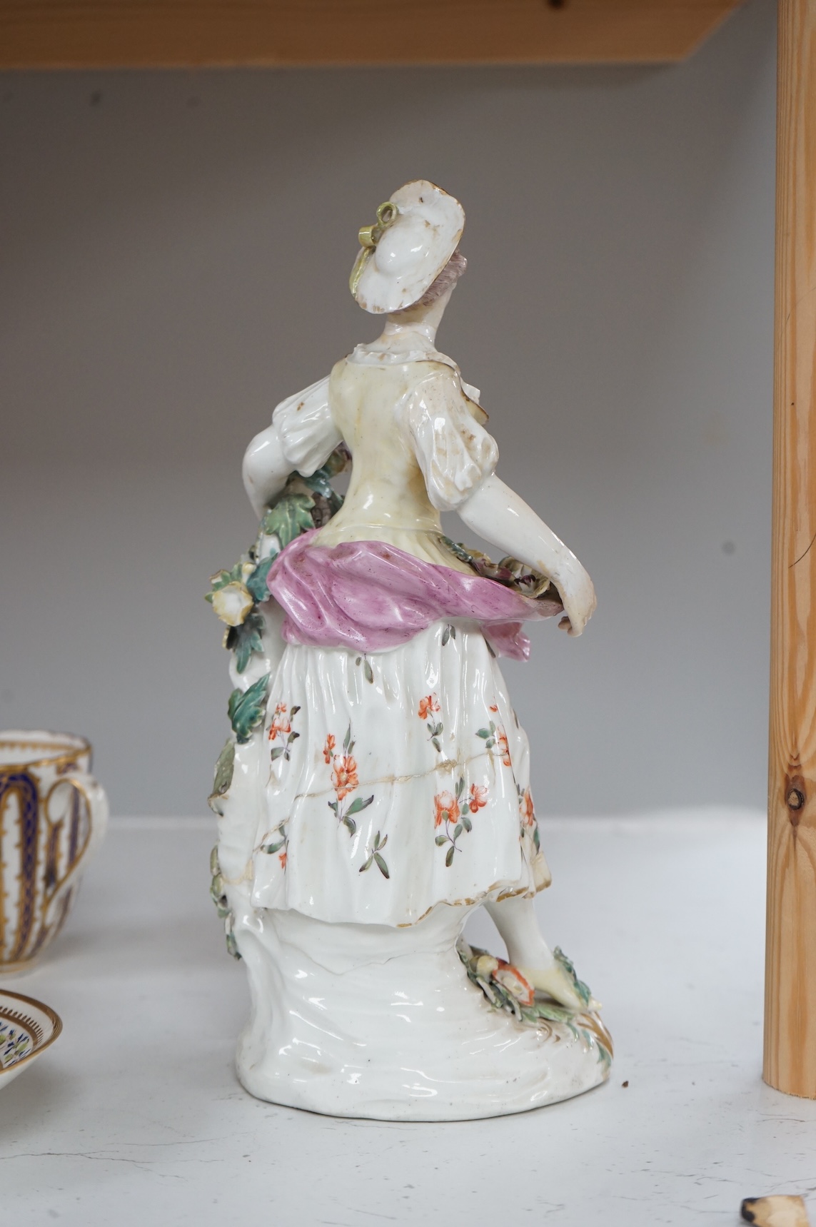 A Derby figure of a flower seller, c.1760, restored, 24cm high